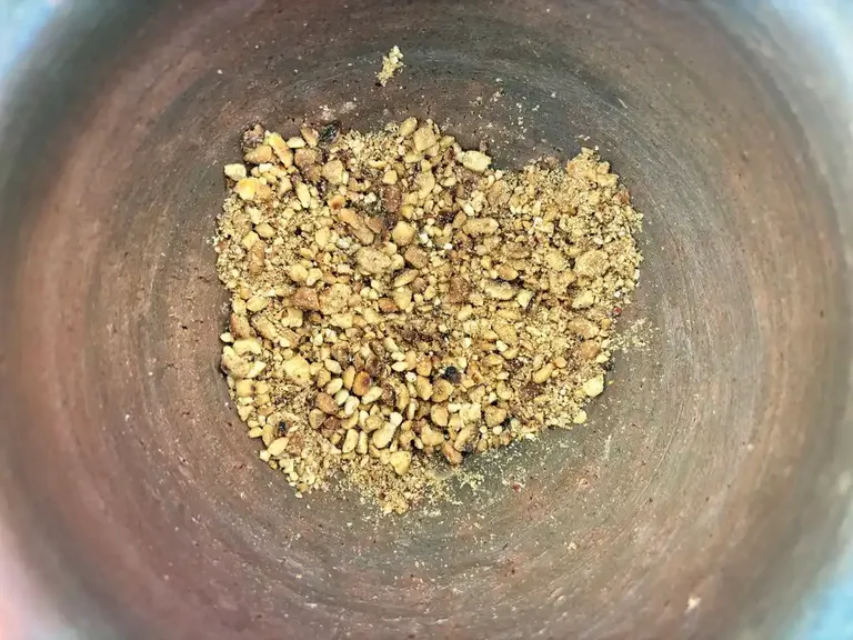 Crushed peanuts in a clay mortar.