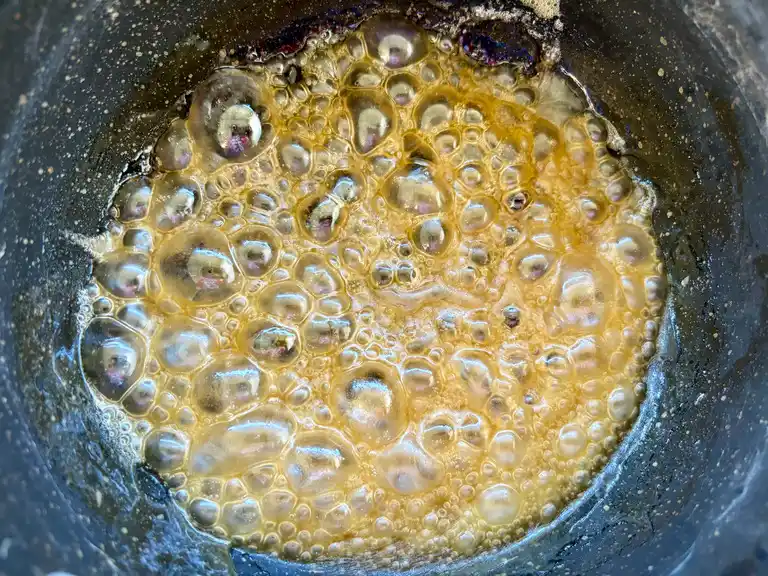 Palm sugar dissolving in a pot, the beginning stage of pad Thai sauce.