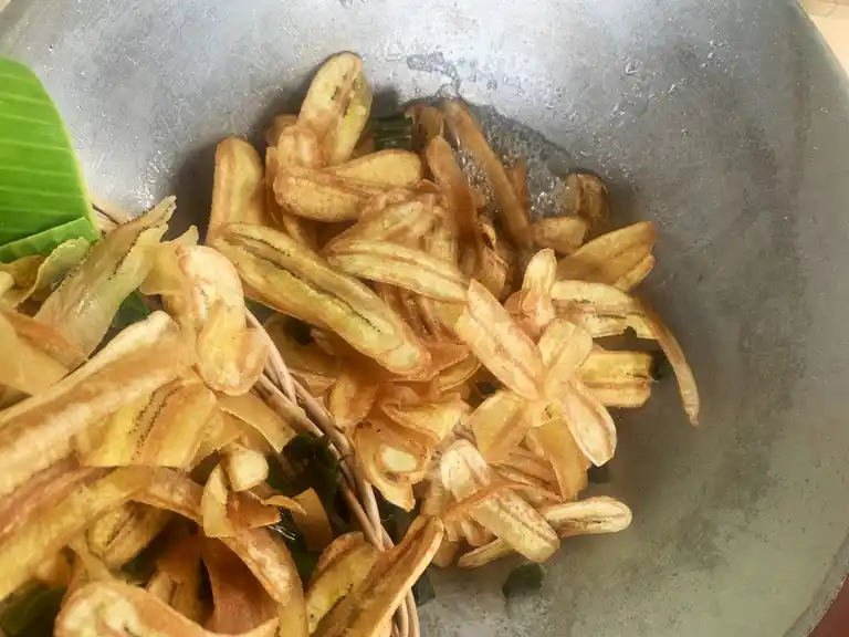 Fried banana chips sugar coated in a wok.