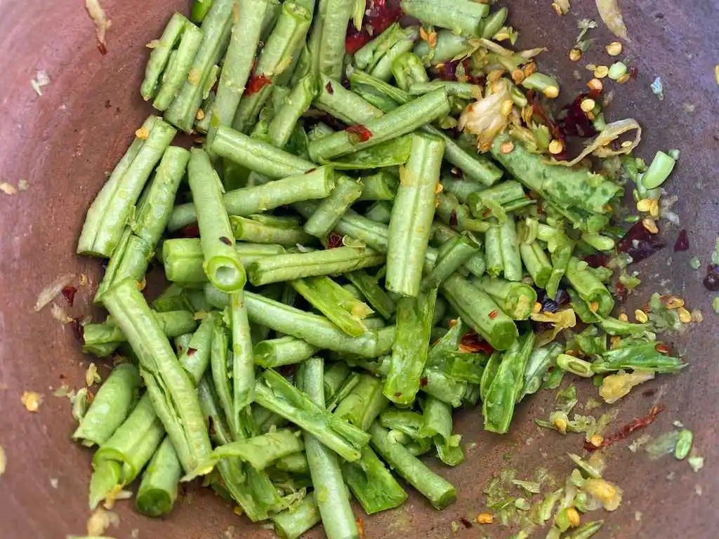 Close-up of pounded yardlong beans in a mortar.