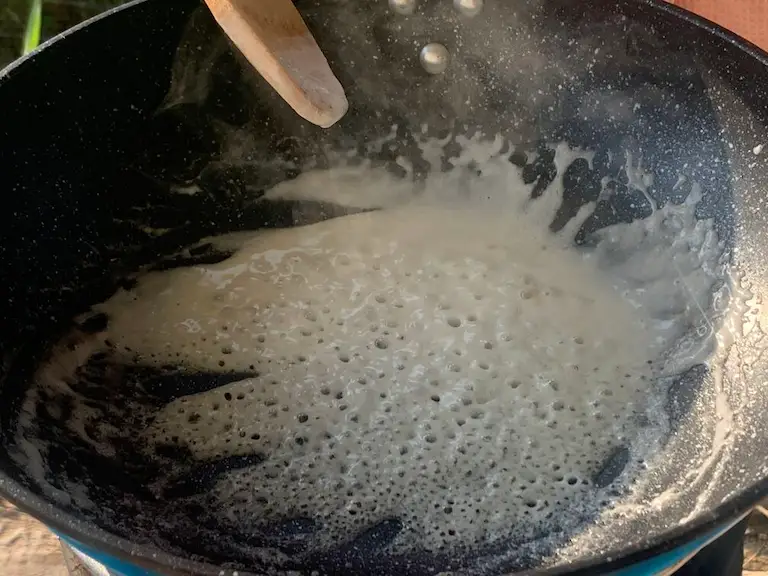 Reduced coconut milk in a wok.