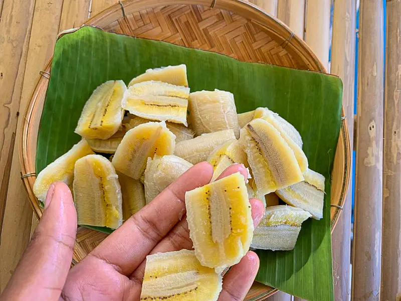Hand holding sliced Thai bananas.