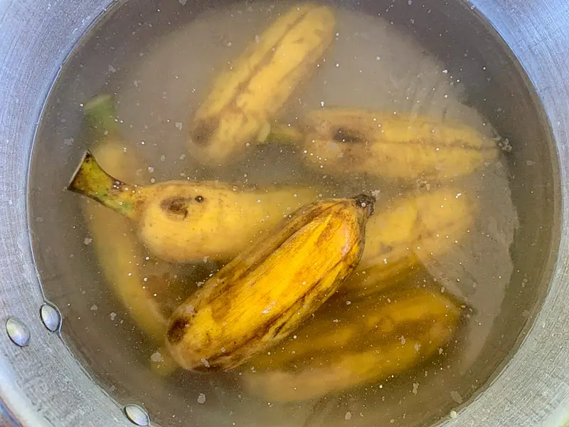 Boiling whole Thai bananas in water.