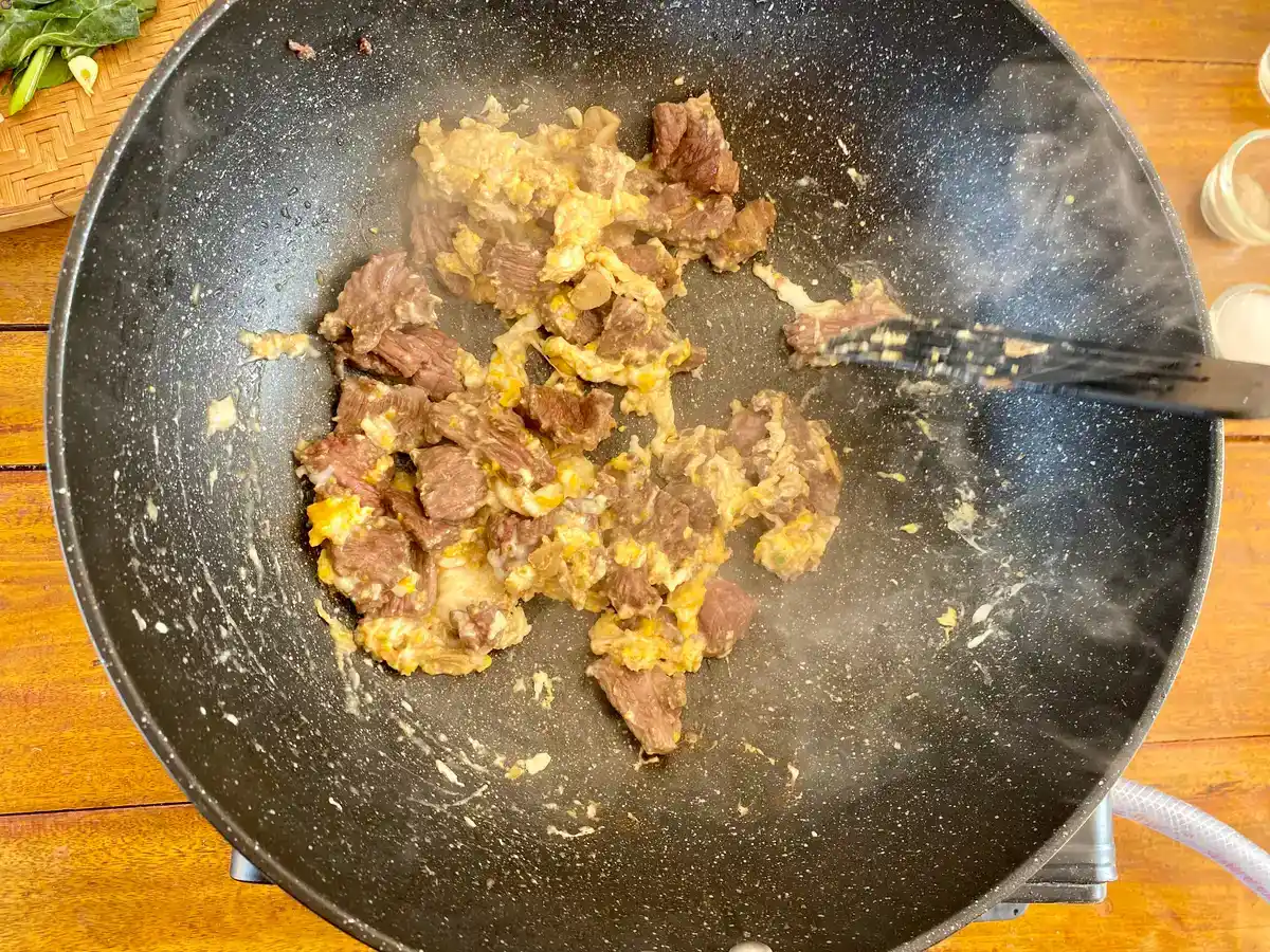 Scrambled eggs mixed with beef in a wok.