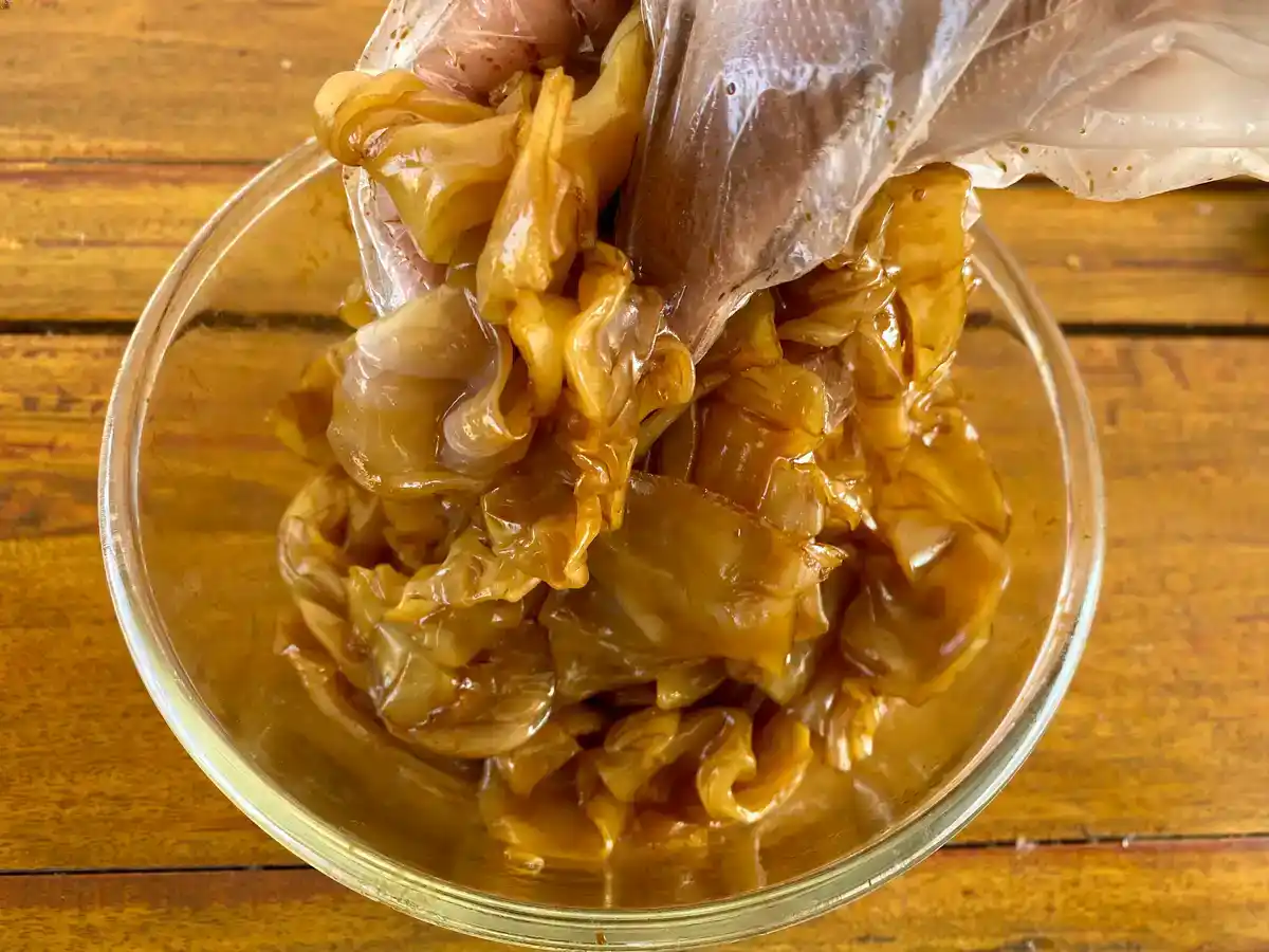 Wide rice noodles coated with soy sauce before cooking.