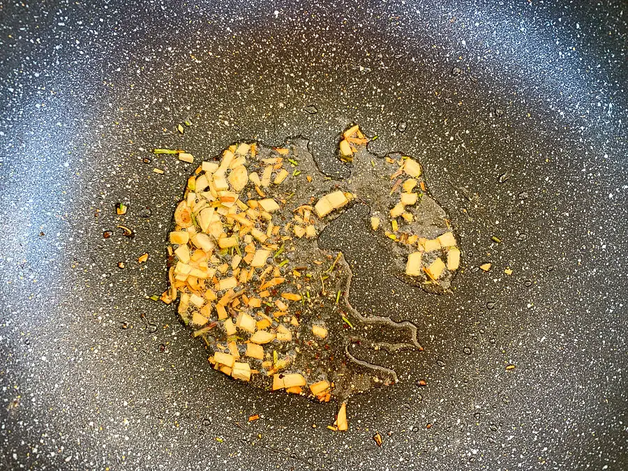 Garlic, coriander root, and black pepper frying in oil.