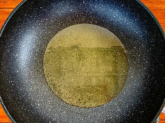 Oil heating in a pan before frying.