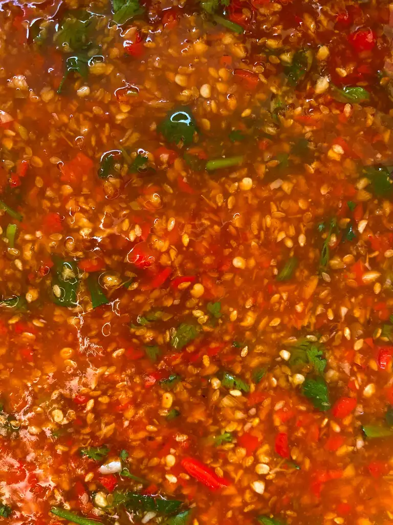 Close-up of mookata chili sauce with coriander leaves on top.