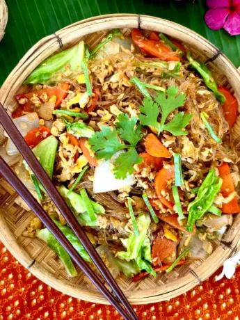 Pad woon sen, Thai glass noodle stir-fry served in a traditional bamboo dish.