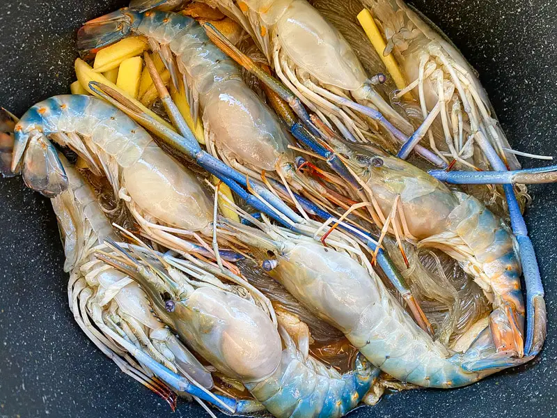 Large prawns layered over glass noodles and ginger before steaming.