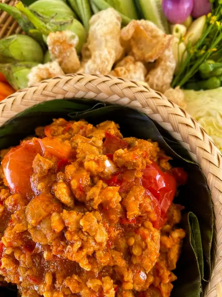 Nam prik ong, a Thai pork and tomato dipping sauce, served with vegetables and pork cracklings.