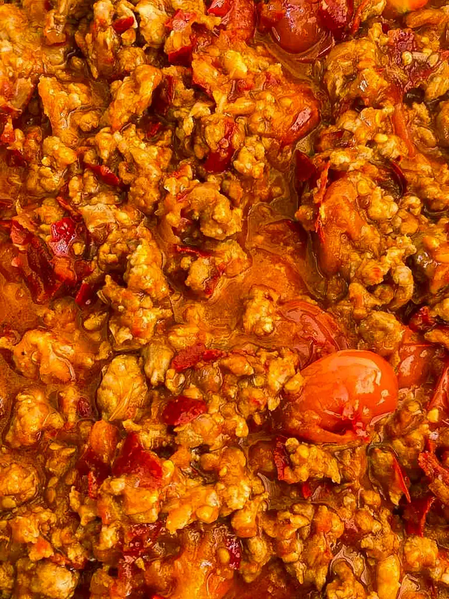 Close-up of nam prik ong with red tomato sauce and ground pork.