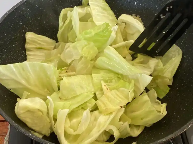 Thai cabbage stir-fry prepared in a wok.