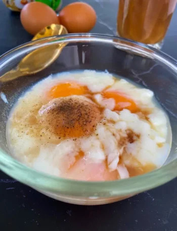 Thai soft-boiled egg kai luak seasoned with pepper in a clear glass bowl.