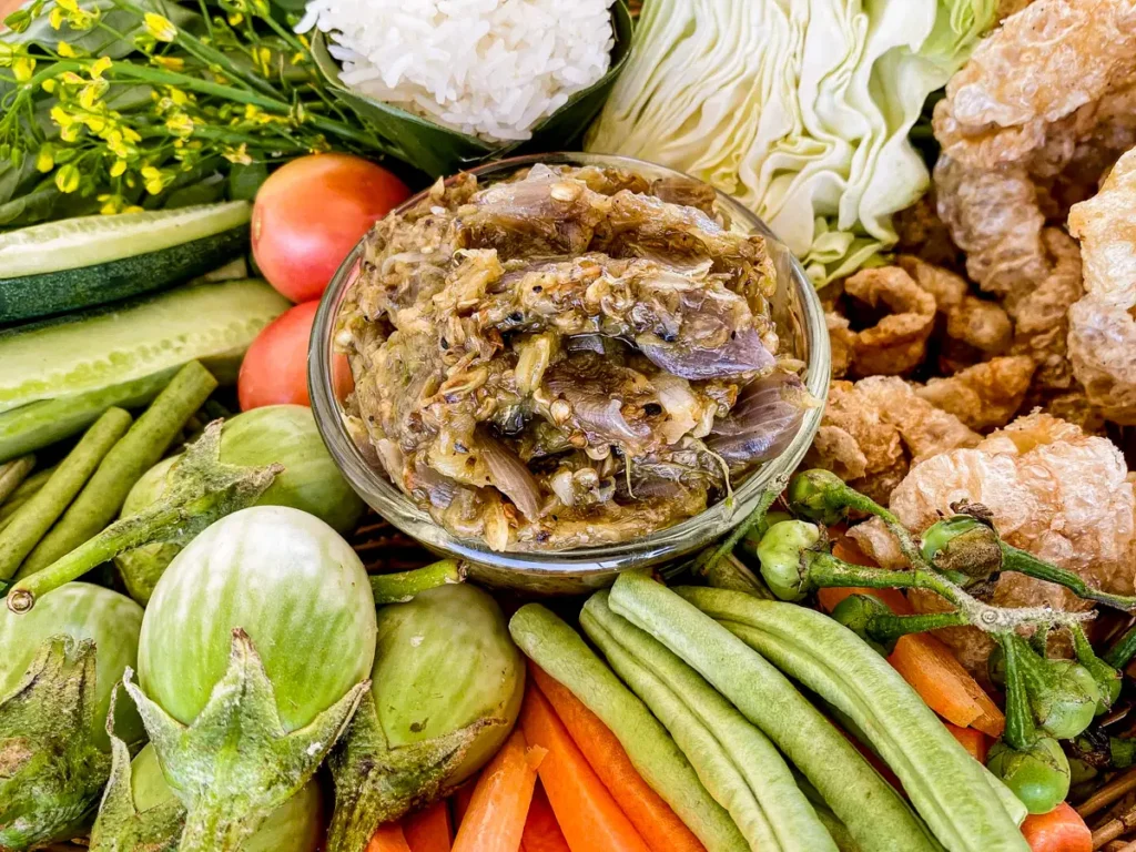 Nam prik noom with fresh vegetables, rice, and pork cracklings.