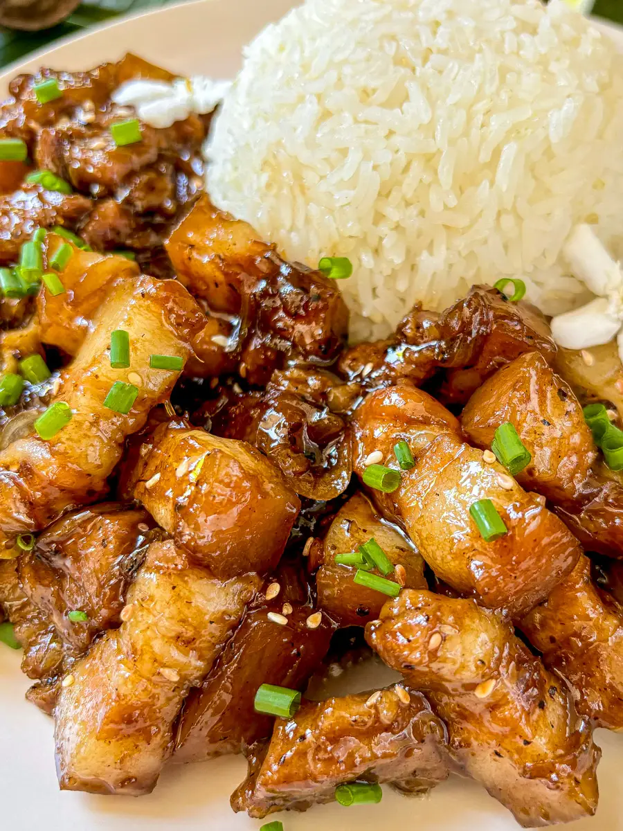 Close-up of Thai sweet pork belly stir-fry, showcasing the caramelized pork belly pieces with a sprinkling of sesame seeds.