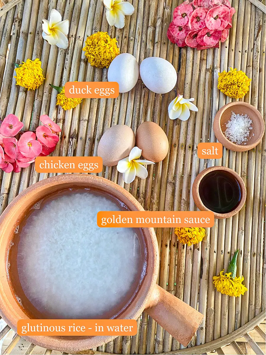 Khao jee ingredients laid out on a bamboo tray with sticky rice, eggs, Golden Mountain Sauce, and salt.