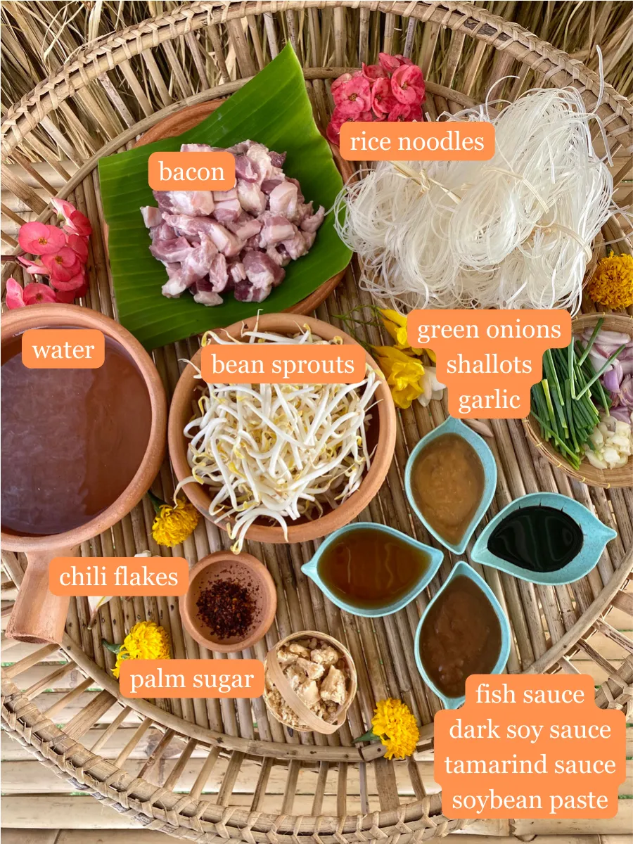 Ingredients for pad mee korat, including rice noodles, pork belly, bean sprouts, garlic, shallots, tamarind, fish sauce, and palm sugar.
