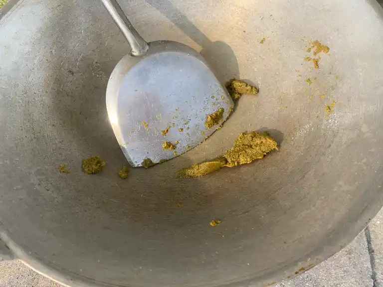 Stir-fried green curry paste in a wok.