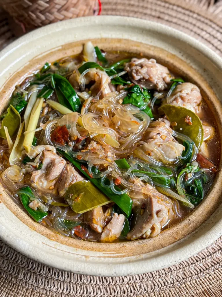 Thai glass noodle soup with chicken, fresh herbs, chilies, lemongrass, and makrut lime leaves