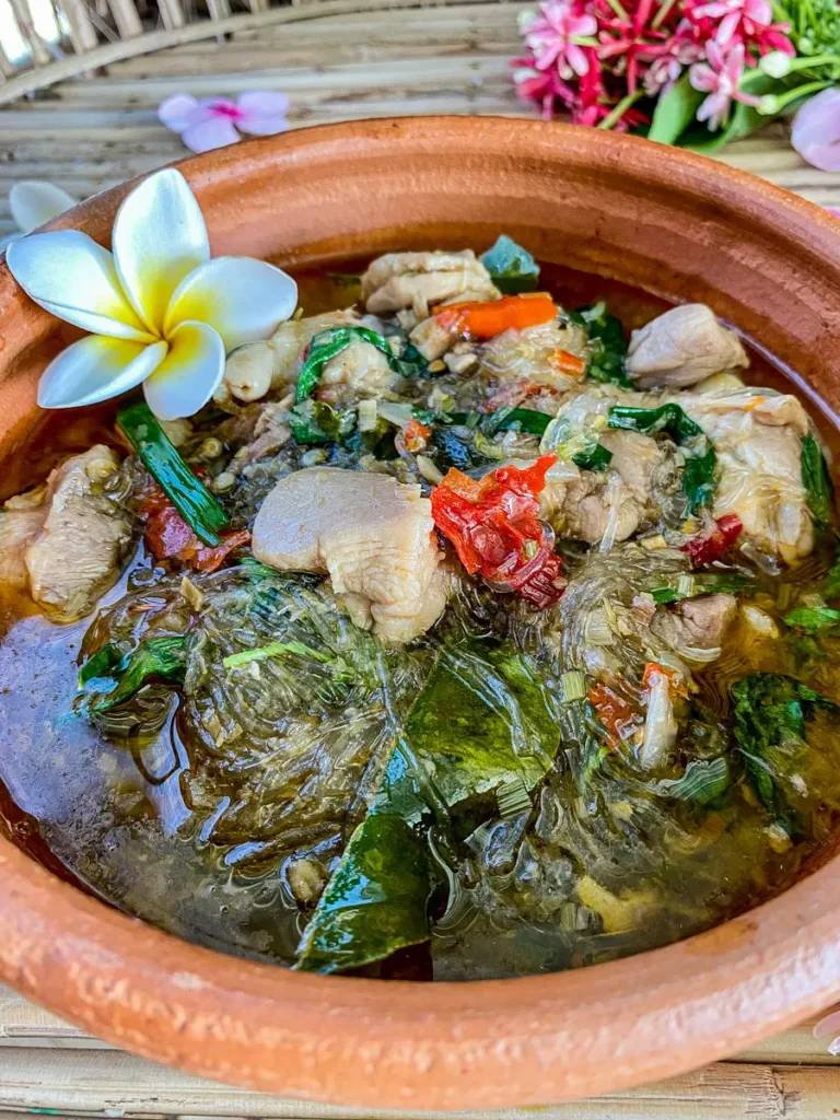 Thai glass noodles soup with chicken served in a clay dish.