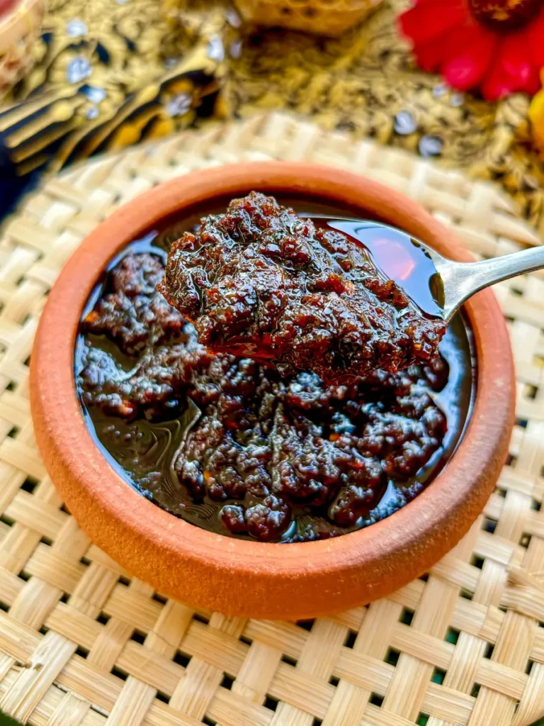 Thai chili paste, nam prik pao, in clay sauce cup with spices around it.