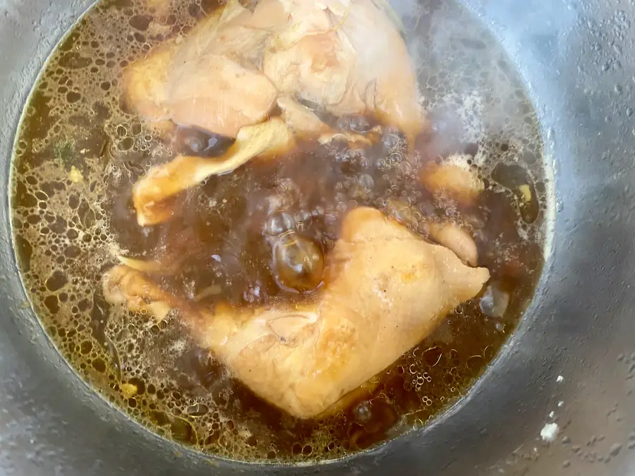 Bone-in chicken thighs simmering in a savory fish sauce broth with Thai aromatics.