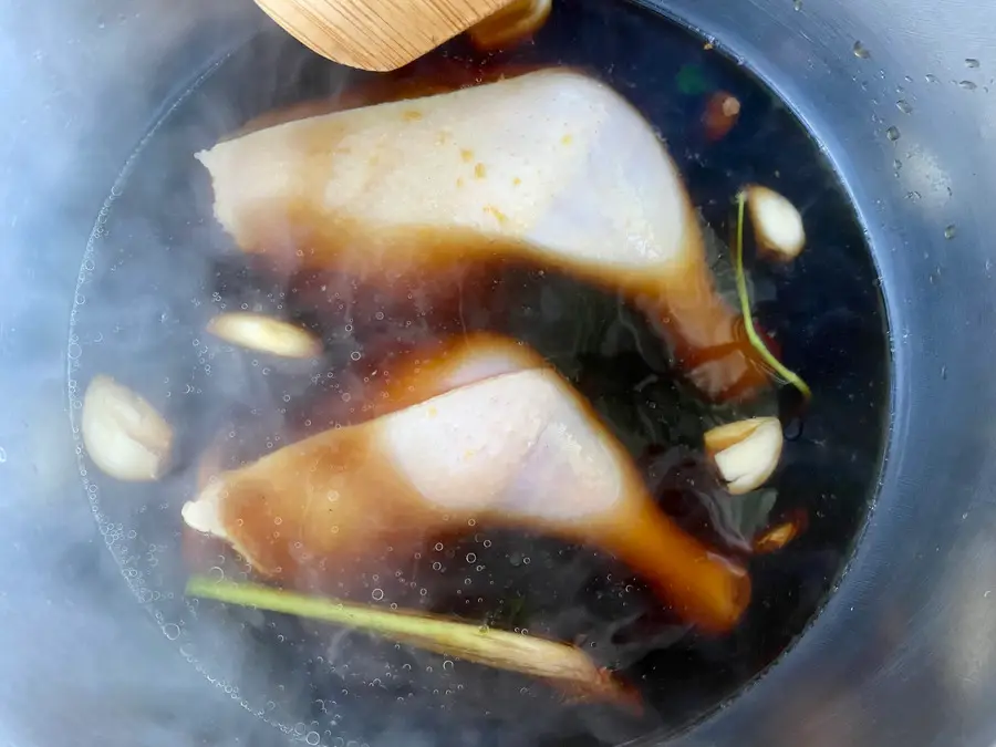 Thai boiled chicken thighs simmering in a savory fish sauce broth.