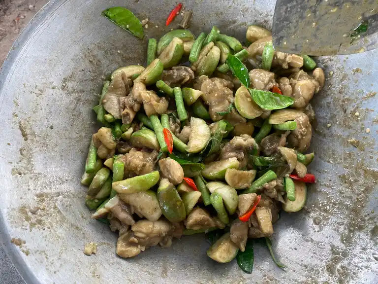 Thai green curry chicken stir-fry ready in a wok.