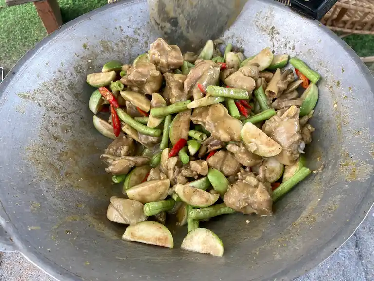 Thai green curry stir-fry preparation in a wok.