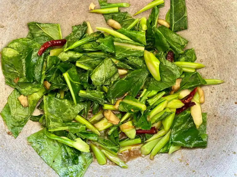 Freshly cooked Chinese broccoli stir-fry with vibrant greens and red chilies in a traditional wok.
