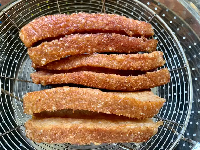 Fried pork belly in a colander.