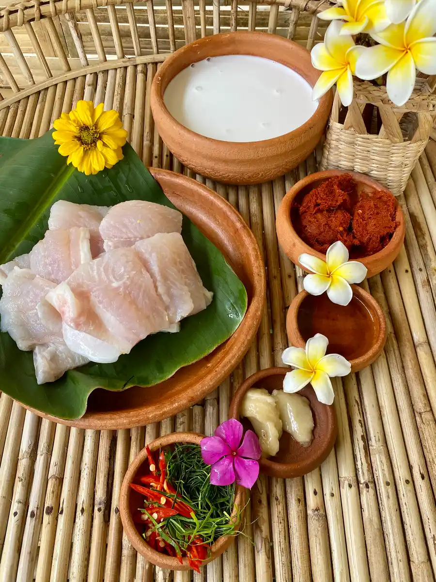 Ingredients for Thai red curry fish: Coconut milk, fish fillets, red curry paste, fish sauce, palm sugar, kaffir lime leaves, and red chilies.