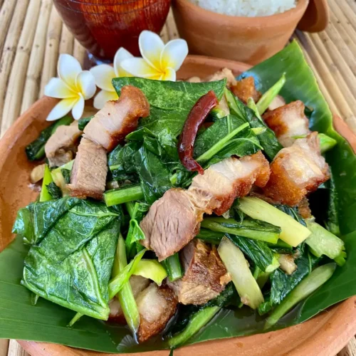Pad kana moo krob, crispy pork belly with Chinese broccoli, ready to be enjoyed alongside steamed rice.