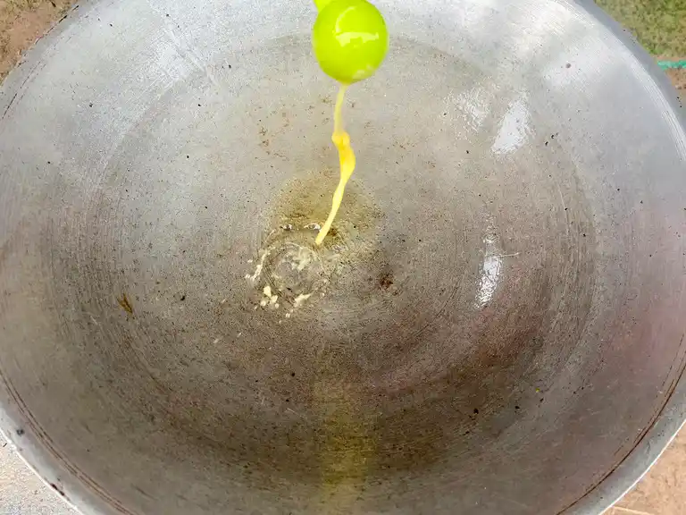 Pouring oil into a hot pan before frying.