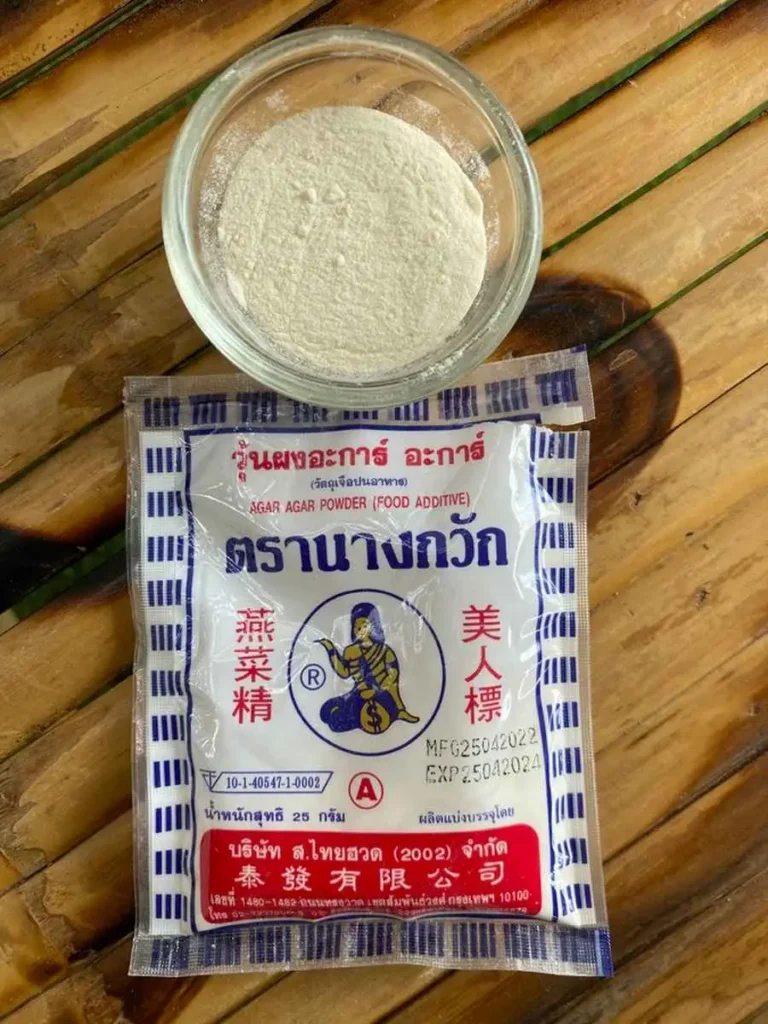 Package of agar-agar powder with agar powder in glass cup.