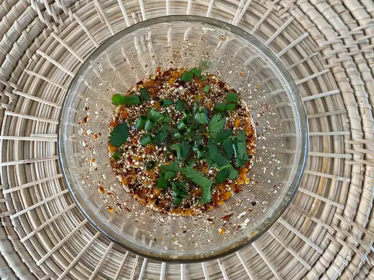 Top-view of crying tiger sauce in a clear bowl.