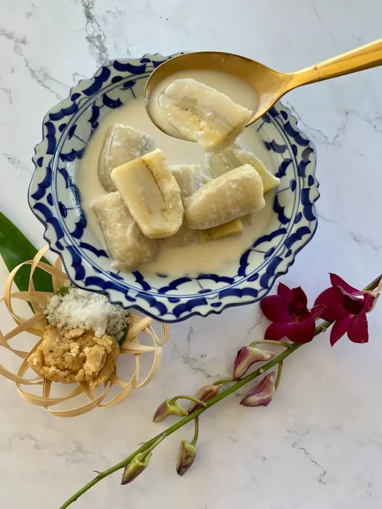 Thai bananas in coconut milk served in a blue bowl.