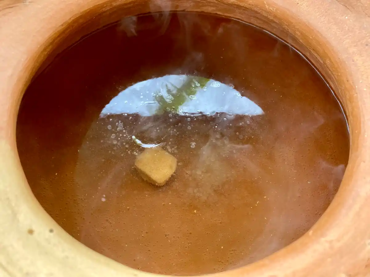 Water in a pot with bouillon cube and pepper.