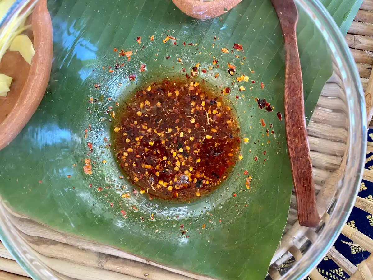Top-down view of a large mixing bowl, containing a spicy, tangy dressing.