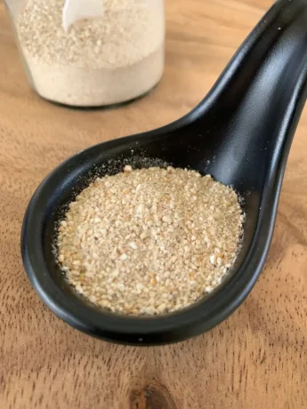 Toasted rice powder in a black spoon.
