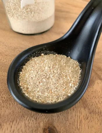 Toasted rice powder in a black spoon.