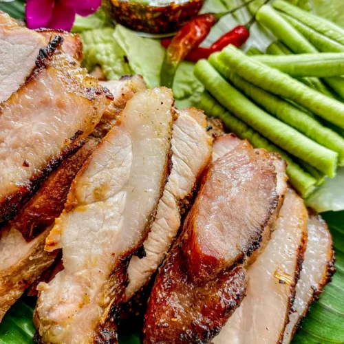Thai grilled pork neck (moo yang) sliced and served with fresh long beans, lettuce, and spicy dipping sauce.