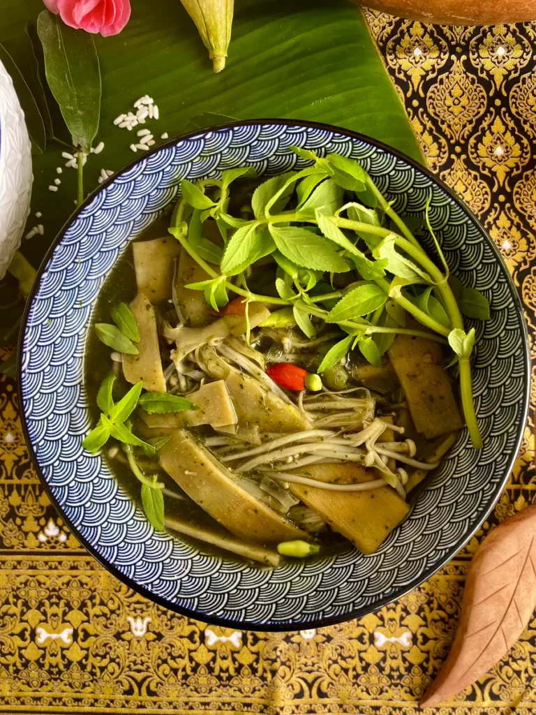 Top-down view of Thai bamboo soup with vegetables in a blue and white bowl 