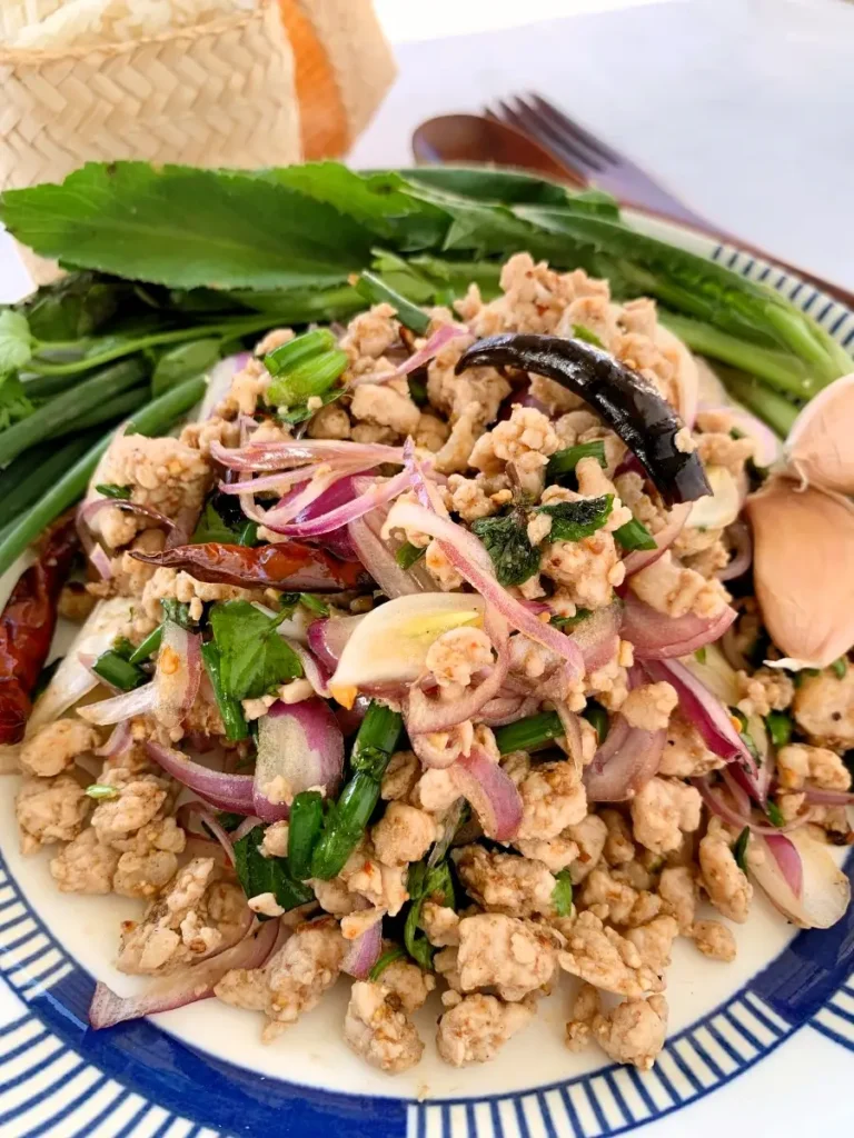 Thai pork larb with fresh vegetables and sticky rice, perfect for an easy dinner.