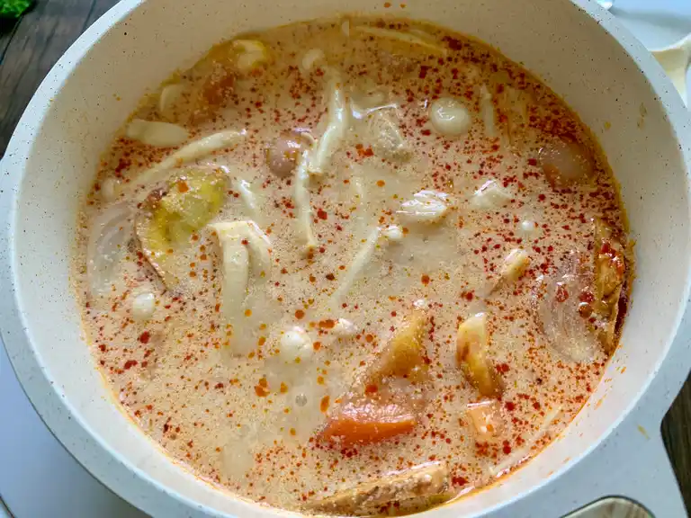 Finished tom yum gai soup with evaporated milk stirred in for a creamy texture.