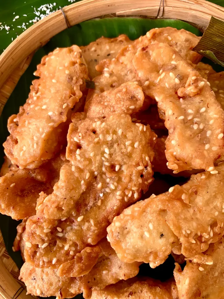 Close-up of deep-fried bananas topped with sesame seeds.