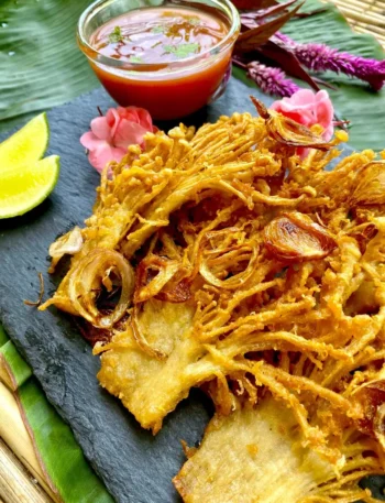 Deep-fried enoki mushrooms served with a lime wedge and spicy chili dipping sauce.