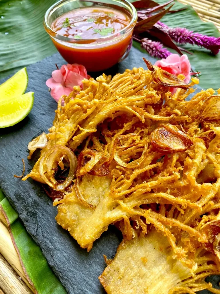 Deep-fried enoki mushrooms served with a lime wedge and spicy chili dipping sauce.