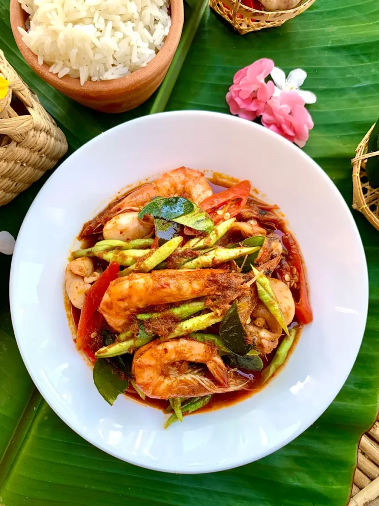 Pad ped talay, spicy Thai seafood stir-fry with beans, shrimp, and squid, served in a white dish for an easy dinner.